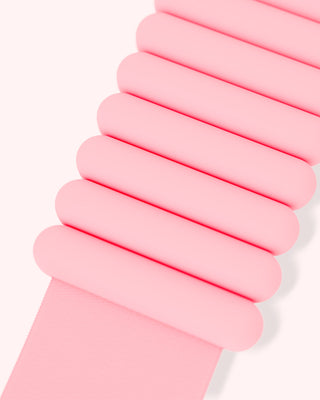 Close-up of a pastel pink object with horizontal, rounded ridges suggesting a soft, rubbery texture. Its uniform minimalist appearance features a light pink background. This is likely part of the Vibrant Bangles Set for an Energizing Look.