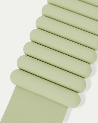 Close-up of a matte, light green band with staggered oval links, showcasing a modern and minimalist design from the Vibrant Bangles Set for an Energizing Look. It extends diagonally across a light, neutral background.
