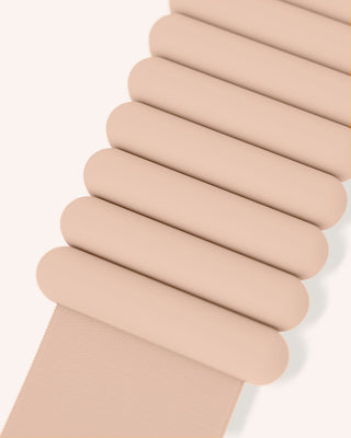 Close-up of the accordion-style strap from the Vibrant Bangles Set for an Energizing Look, featuring evenly spaced, rounded segments. It's crafted from a soft, flexible material and positioned diagonally across a pale background.