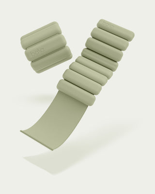 A pair of light green Vibrant Bangles Set for an Energizing Look, featuring a modern segmented design. One is laid flat and the other stacked, both embossed with "Bala," against a matching background, creating a clean and minimalist aesthetic.
