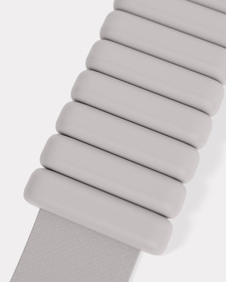 Close-up of a light gray strap with rounded, rectangular segments in an accordion style. This partial view reveals a symmetrical pattern and smooth texture, embodying a clean, minimalist design. As part of the Vibrant Bangles Set for an Energizing Look, it adds charm and simplicity to your style.