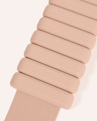 Close-up of a beige accordion-style strap with rectangular segments resembling stacked cushions, diagonally set on a light background for a minimalist look. Similar style to the Vibrant Bangles Set for an Energizing Look.
