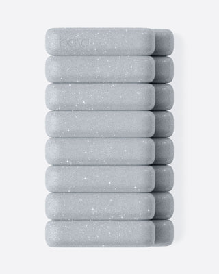 Ten gray rectangular soap bars are arranged horizontally, each identical with smooth, rounded edges and a slightly speckled texture. The minimalist design creates a clean aesthetic against the white background.