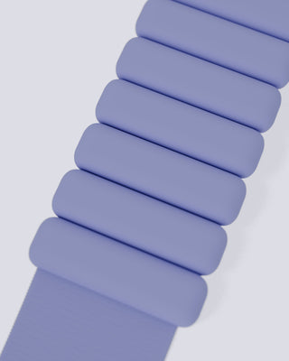 Close-up of the Vibrant Bangles Set's purple silicone watch band, showcasing its segmented pillowed texture with soft, rectangular sections aligned in a row. The plain light grey background accentuates the modern and sleek design.