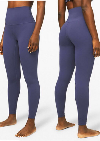 A person is barefoot on a plain white background, showcasing the front and back views of snug-fitting, ankle-length High-Waist Powercore Legging in Lavender Gray to highlight the design and fit.