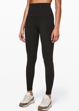 A person wearing black High-Waist Powercore Leggings and white sneakers. The seamless, fitted design highlights a sleek look ideal for both sports and casual wear, set against a plain white background to emphasize simplicity and elegance.