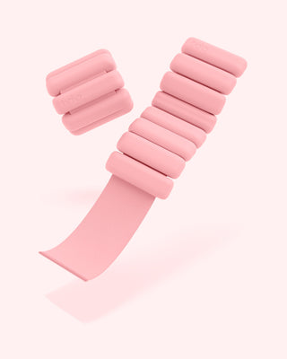 A pair of blush adjustable bangle weights from the Vibrant Bangles Set for an Energizing Look are displayed on a white background. Each consists of cylindrical segments on a flexible strap, with "bala" engraved on them.