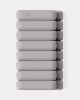 A set of six light gray, rectangular Vibrant Bangles wrist weights with rounded edges features the embossed "bala" logo on top. They are neatly aligned against a plain white background.